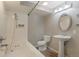 This full bathroom features a pedestal sink, oval mirror, white ceramic tile surround, and a soaking tub with jets at 11894 Elk Head Range Rd, Littleton, CO 80127