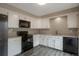 Bright kitchen featuring white cabinetry, dark appliances, and gray countertops at 11894 Elk Head Range Rd, Littleton, CO 80127