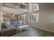 Inviting living room featuring modern gray tones, hardwood floors, and a large window at 11894 Elk Head Range Rd, Littleton, CO 80127