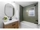 Charming bathroom featuring a tub with tiled walls, updated fixtures, and a stylish vanity at 3912 S Acoma St, Englewood, CO 80110