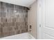 Elegant bathroom features a tub with stylish tiled shower and updated fixtures at 3912 S Acoma St, Englewood, CO 80110