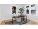 Bright home office features a modern desk, area rug, and two large windows for natural light at 3912 S Acoma St, Englewood, CO 80110