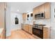 Bright kitchen features stainless steel appliances, natural wood cabinets, and hardwood floors at 3912 S Acoma St, Englewood, CO 80110