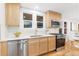 Well-lit kitchen with stainless steel appliances, natural wood cabinets, and ample counter space at 3912 S Acoma St, Englewood, CO 80110