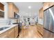 Open kitchen with stainless steel appliances and hardwood floors leads to dining and living areas at 3912 S Acoma St, Englewood, CO 80110