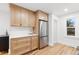 Kitchen with stainless steel appliances, light wood cabinets, and stone countertops at 3912 S Acoma St, Englewood, CO 80110