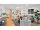 Bright living room featuring stylish furniture, hardwood floors, and an open layout to the kitchen at 3912 S Acoma St, Englewood, CO 80110