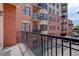 Balcony view showcasing brick buildings and landscaped courtyard in a vibrant urban setting at 410 Acoma St # 212, Denver, CO 80204