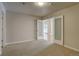 Well-lit carpeted room with neutral walls and white trim; open doors leading to additional living space at 410 Acoma St # 212, Denver, CO 80204