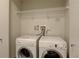 Laundry room with white appliances and overhead shelving for functional convenience at 410 Acoma St # 212, Denver, CO 80204