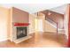 Bright living room featuring wood floors, a brick fireplace, and a staircase at 19421 E Milan Cir, Aurora, CO 80013