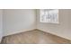 Bright empty room featuring new hardwood floors, fresh paint, and a large window at 298 Chardon Ave, Brighton, CO 80601