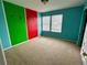 Colorful bedroom featuring multi-colored accent wall and double windows at 10117 Granby St, Commerce City, CO 80022