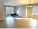 Bright and airy living room with wood-look floors, modern light fixture and plenty of natural light from the large windows at 10117 Granby St, Commerce City, CO 80022