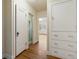 Hallway with hardwood floors, leading to a bathroom and room with natural light at 265 S Pennsylvania St, Denver, CO 80209