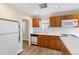 Kitchen with wood cabinets, white appliances and hardwood floors at 265 S Pennsylvania St, Denver, CO 80209