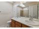 Bright bathroom featuring dual sinks, white countertops, and a shower with tile surround at 2626 Tamarac St, Denver, CO 80238