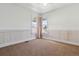 Bedroom featuring a corner window, paneled walls, and carpet flooring for a cozy and inviting space at 2626 Tamarac St, Denver, CO 80238