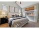 Cozy bedroom featuring a large window, neutral color palette, and stylish decor with a ceiling fan at 2626 Tamarac St, Denver, CO 80238