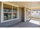 Covered front porch with a large window and grey siding at 2626 Tamarac St, Denver, CO 80238