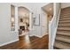 Bright hallway with hardwood floors, staircase, and arched entry to the living room at 2626 Tamarac St, Denver, CO 80238