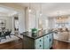 Open-concept kitchen island with seating, pendant lights, and views into the living and dining areas at 2626 Tamarac St, Denver, CO 80238