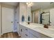 Bathroom with double sinks, white cabinets, and a large mirror reflecting a glass door shower at 15869 E Otero Ave, Centennial, CO 80112