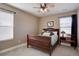 Cozy bedroom with a dark wood bed frame, ceiling fan, and ample natural light from two windows at 15869 E Otero Ave, Centennial, CO 80112