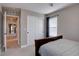 Neutral bedroom with a dark wood bed frame, sliding closet doors, and a view into the hallway at 15869 E Otero Ave, Centennial, CO 80112