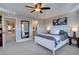 This main bedroom features a ceiling fan, adjacent bathroom and hall, and modern furniture at 15869 E Otero Ave, Centennial, CO 80112