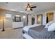 Bright main bedroom featuring a ceiling fan, a dresser, and an adjacent view of the main bathroom at 15869 E Otero Ave, Centennial, CO 80112