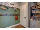 This mud room features coat hooks, a gray storage cabinet, and a patterned wall behind a white interior door at 15869 E Otero Ave, Centennial, CO 80112