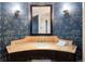 Elegant powder room featuring stylish wallpaper, marble counter, and a decorative mirror with sconces at 67 Indigo Way, Castle Rock, CO 80108