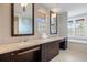 Bathroom with double sinks, custom cabinetry, and a luxurious soaking tub next to a window at 67 Indigo Way, Castle Rock, CO 80108