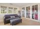 Bright bedroom with a gray couch, ottoman, large windows and glass-enclosed walk-in closet at 67 Indigo Way, Castle Rock, CO 80108