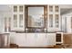 An elegant wet bar area is appointed with granite counters, wine storage, and glass front cabinetry at 67 Indigo Way, Castle Rock, CO 80108