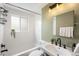 Updated bathroom with a tub-shower, tile surround, and stylish fixtures, creating a clean and modern aesthetic at 5740 S Cherokee St, Littleton, CO 80120