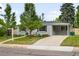 Attractive single-story home featuring a covered carport and concrete driveway, complemented by a well-kept lawn at 5740 S Cherokee St, Littleton, CO 80120