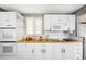 Bright kitchen featuring white cabinets, a double oven, and updated appliances, and a window with a unique pattern shade at 5740 S Cherokee St, Littleton, CO 80120