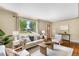 Comfortable living room featuring hardwood floors, natural light, and stylish, neutral-toned furniture at 5740 S Cherokee St, Littleton, CO 80120