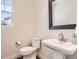 Half bathroom featuring a toilet, pedestal sink, and an ornate mirror at 15705 Red Deer Dr, Morrison, CO 80465