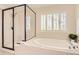 Bathroom featuring a glass-enclosed shower, soaking tub, and plantation shutters at 15705 Red Deer Dr, Morrison, CO 80465