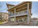 A multi-level home with a patio, stone foundation, brown siding, and a lush green artificial lawn at 15705 Red Deer Dr, Morrison, CO 80465