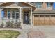 Inviting home exterior featuring stone accents, a covered porch, and manicured landscaping with a three-car garage at 15705 Red Deer Dr, Morrison, CO 80465