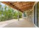 Covered patio with stone siding, exposed wood ceiling, and access to the backyard at 15705 Red Deer Dr, Morrison, CO 80465