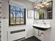 A vintage-style bathroom with white tile walls, a black and white floor, and a unique double faucet sink at 6330 Montview Blvd, Denver, CO 80207