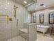 Bright bathroom featuring a glass-enclosed shower, soaking tub, and classic tiling for a relaxing and stylish space at 6330 Montview Blvd, Denver, CO 80207