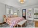 Bright bedroom featuring patterned bedding, bench and a private exterior door to the rear of the property at 6330 Montview Blvd, Denver, CO 80207