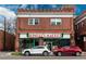 Two-story brick commercial building featuring Spinelli's Market, an Italian deli with cars parked in front at 6330 Montview Blvd, Denver, CO 80207