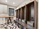 Organized mudroom features custom lockers with storage, a built-in desk, and decorative herringbone tile flooring at 6330 Montview Blvd, Denver, CO 80207